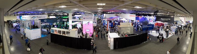 Overhead view of trade show floor with multiple vendor booths and conference attendees