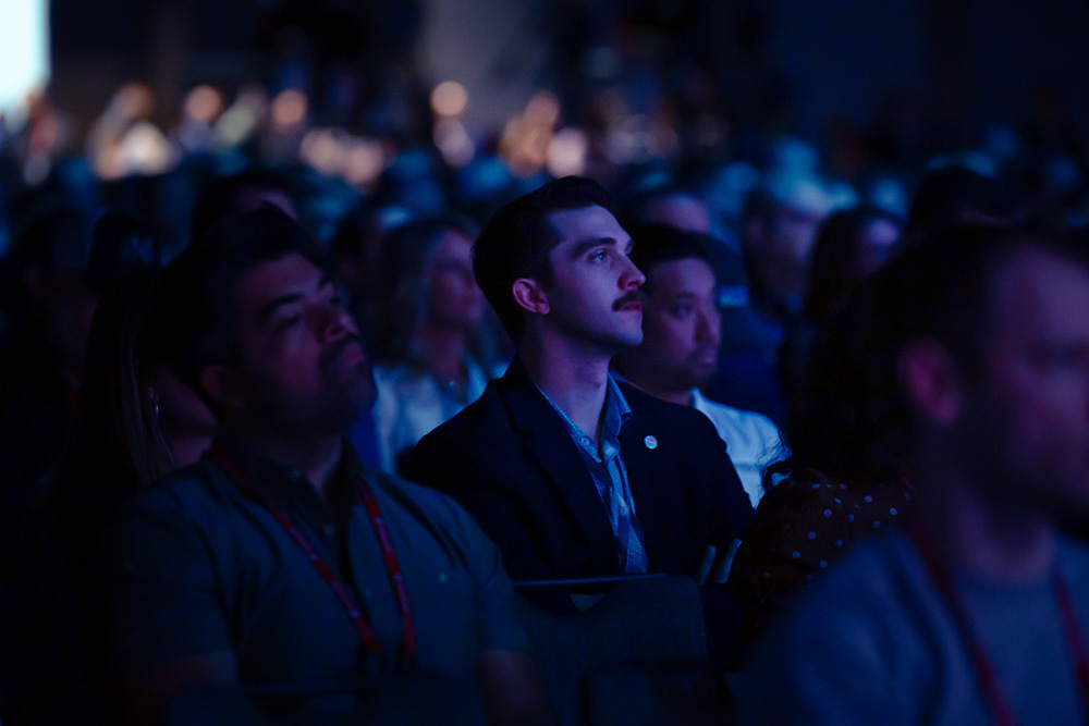 Photo of a person sitting in an audience looking inspired