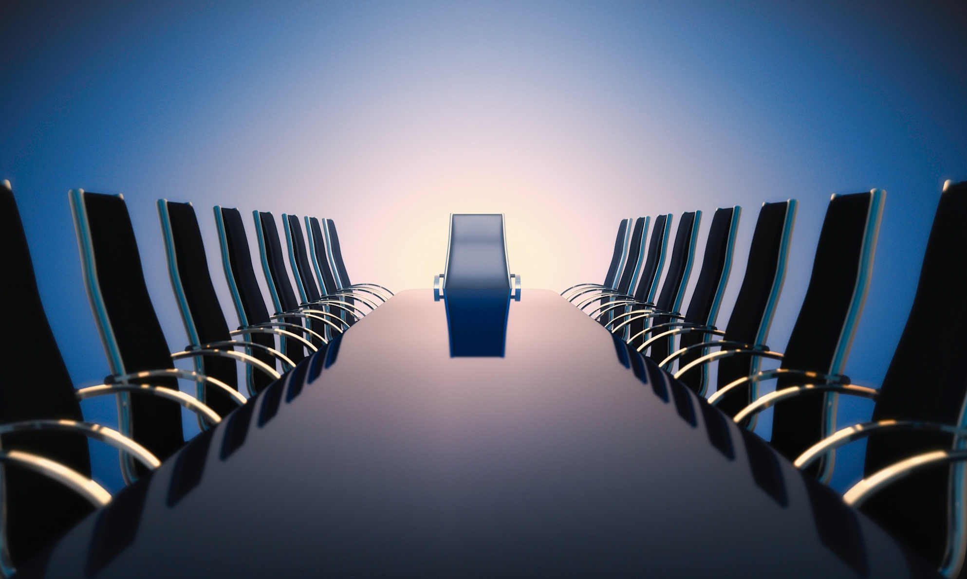 A long, black boardroom table buffed to a high-gloss finish and lined with chairs stretches into the distance, with a sunrise beyond.