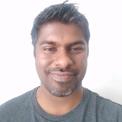 Photo of a brown-skinned man with short black hair and a goatee, and wearing a gray t-shirt.