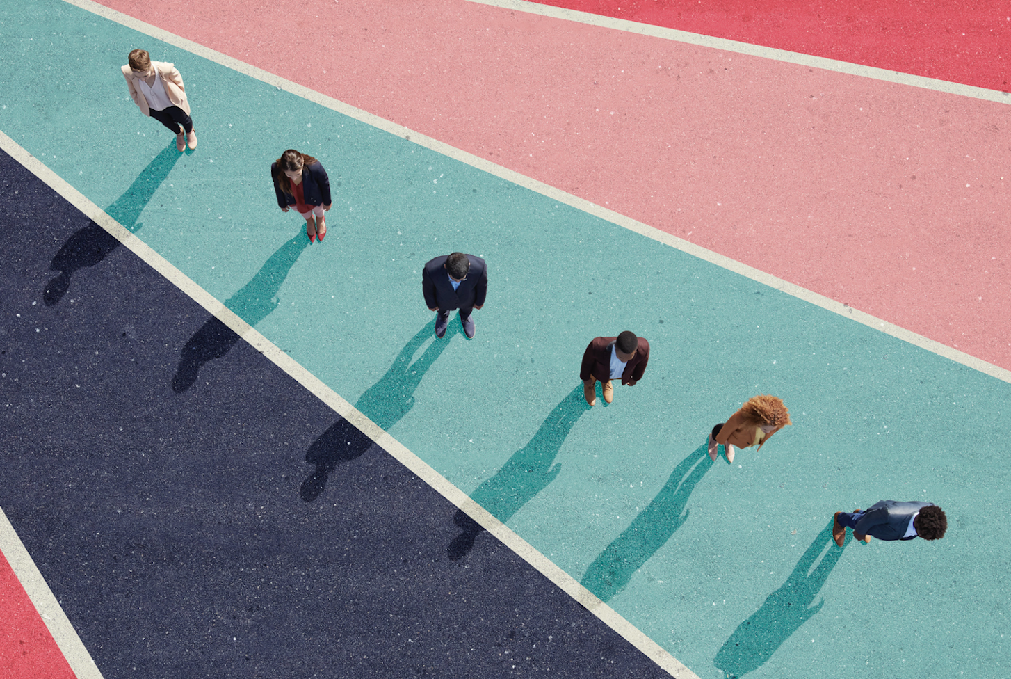 A photo of office workers, seen from above, standing on pavement painted in vivid stripes.